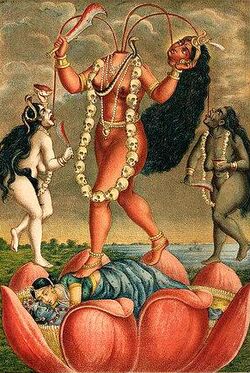 A decapitated, nude, red-complexioned goddess stands on a nuni inside a large lotus. She holds her severed head and a scimitar. Three streams of blood from her neck feed her head and two nude, red-coloured women holding a scimitar and a male severed head, who flank her. All three wear a garland of severed heads, a serpent (around her neck) and various gold and pearl jewellery.