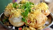 Small, round puris with a filling topped with sev.